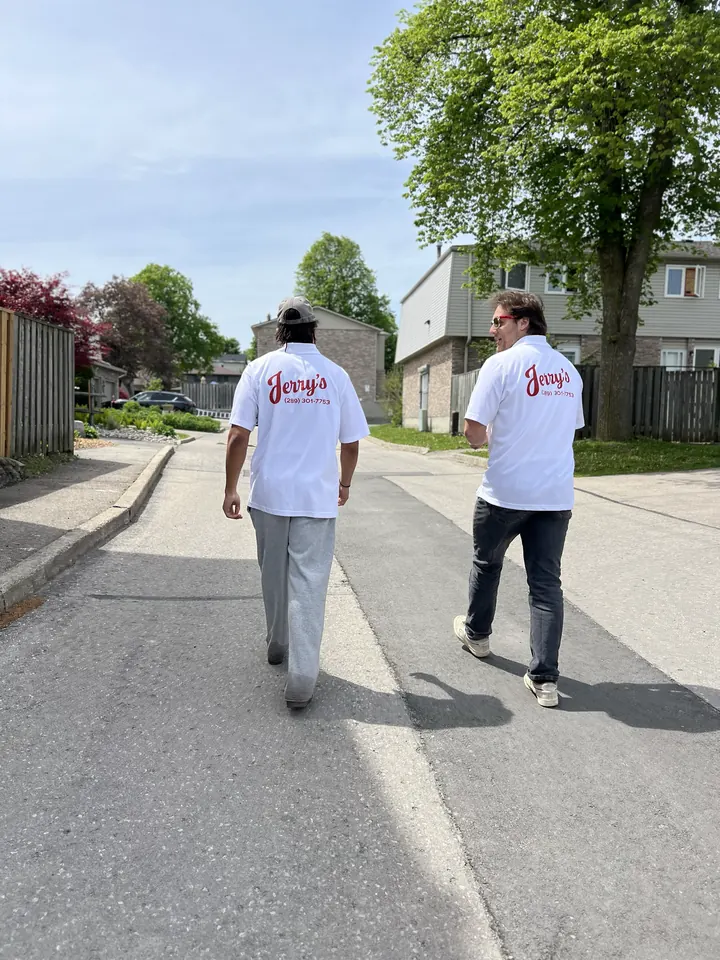 Two of Jerry's crew walking up a street in their red-and-white Jerry's shirts