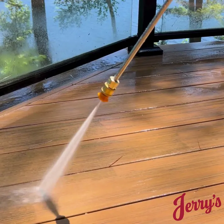 Power washing a wood deck, the cleaned boards showing their colour again