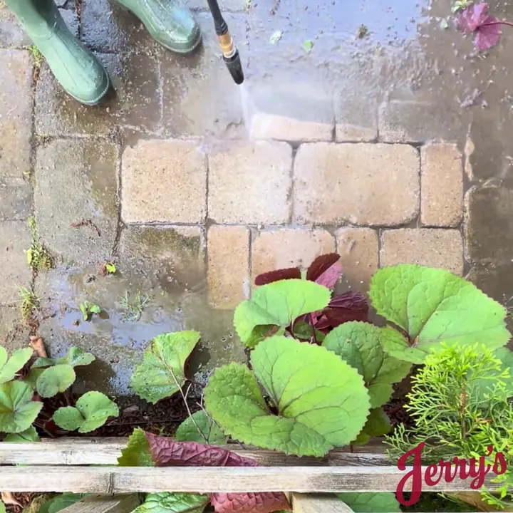 Power washing an interlock retaining wall above a garden bed