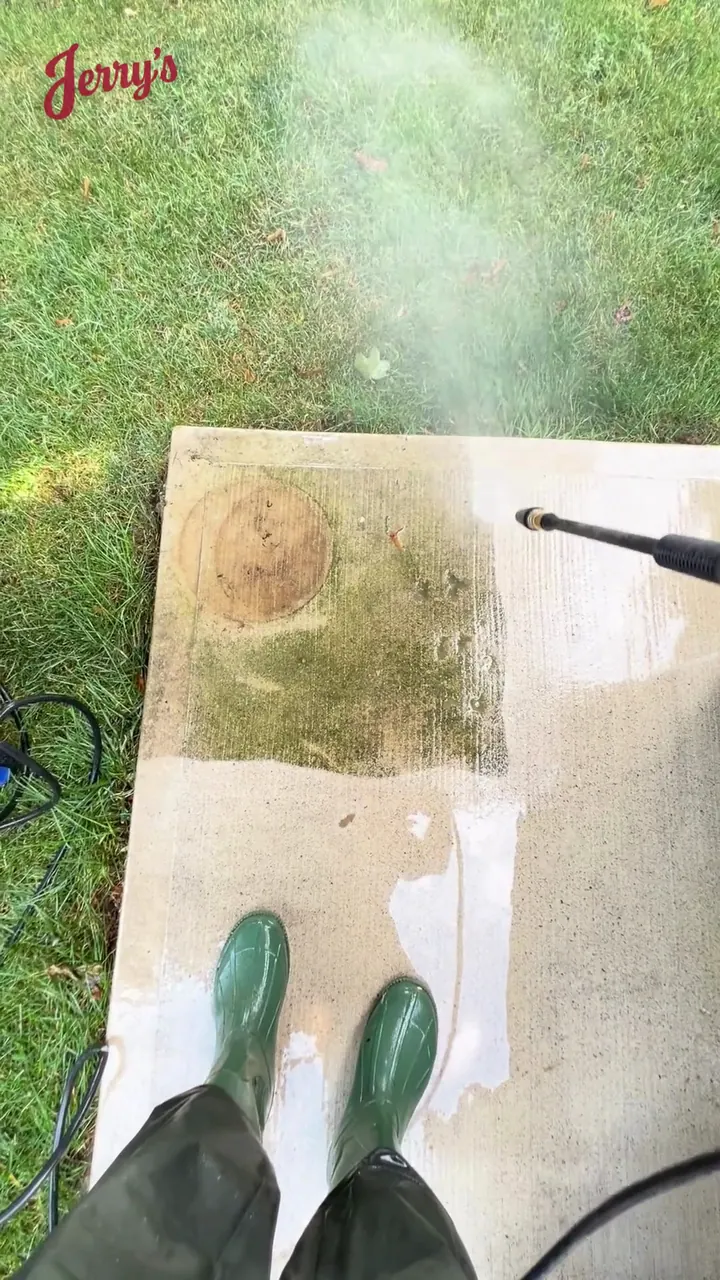 A test patch on a stone paver: the cleaned square next to years of moss and grime
